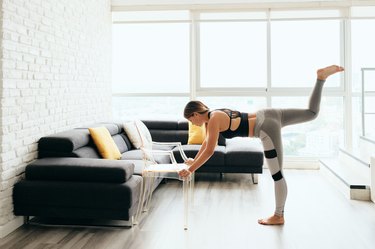 Adult Woman Training Body By Raising Legs Using Chair