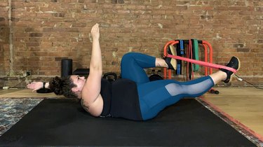 Woman doing a resistance band ab workout at the gym