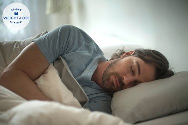 man in blue shirt sleeping on his side