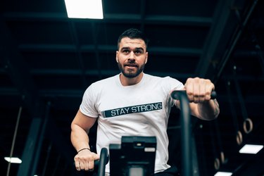 Man in a gym, training on an assault bike