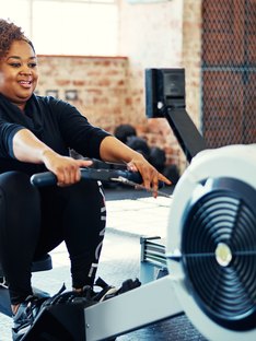 Woman doing a cardio workout on the rowing machine at her gym