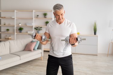 Athletic middle-aged man doing an upper-body workout over 50 at home