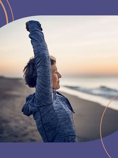 A woman with arthritis stretching on the beach
